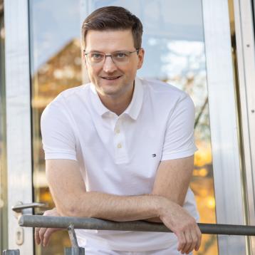 Dr. Epp lehnt draußen an einem Geländer